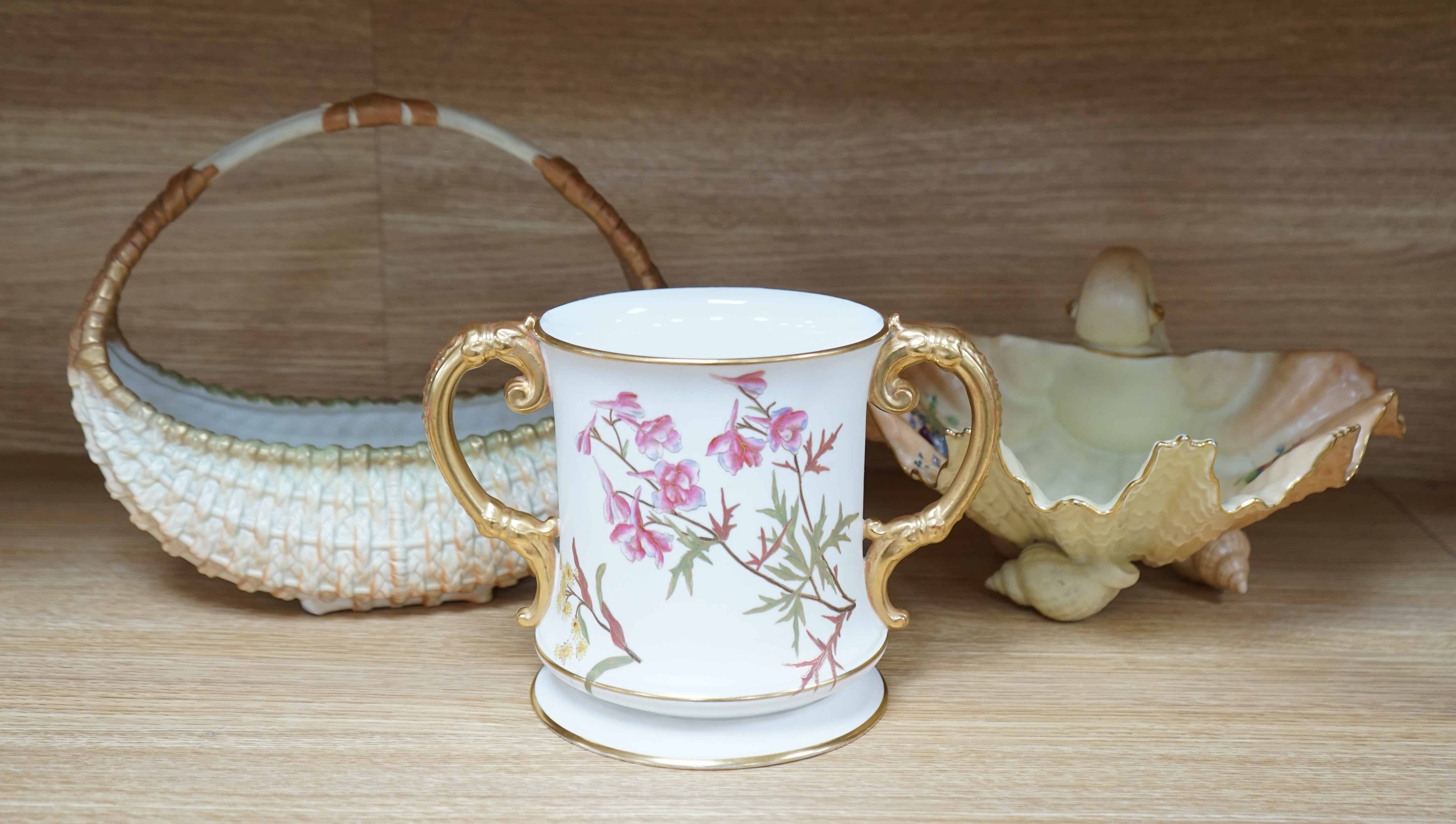 A Royal Worcester blush ivory basket, a shell dish and an ivory coloured two handled mug, 15.5cm (3). Condition - fair to good